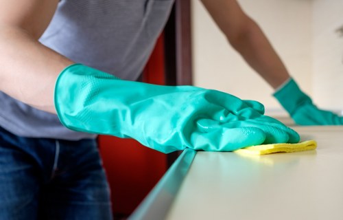 Trained cleaner using PPE during a carpet cleaning job